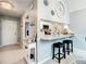 Inviting entryway with a breakfast bar, white cabinets, neutral countertops, and two comfortable stools at 116 Duck Hawk Cir # 3040, Daytona Beach, FL 32119