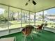 Screened-in porch with green turf, ceiling fan, and water view at 116 Duck Hawk Cir # 3040, Daytona Beach, FL 32119