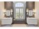 This bathroom features dual sinks, neutral walls, tiled accent walls, and a window for bright natural light at 133 Via Capri, New Smyrna Beach, FL 32169