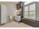 This sleek bathroom features a modern vanity, gray accents, and a tall window for ample natural light at 133 Via Capri, New Smyrna Beach, FL 32169