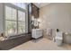 This luxurious bathroom features neutral tile, modern lighting and a window offering plenty of natural light at 133 Via Capri, New Smyrna Beach, FL 32169