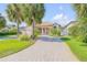 Charming home featuring a neatly manicured lawn and a brick driveway leading to a two-car garage at 133 Via Capri, New Smyrna Beach, FL 32169