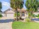 Charming single-story home boasting an attached two-car garage, lush landscaping, and a brick paver driveway at 133 Via Capri, New Smyrna Beach, FL 32169