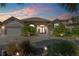 Beautiful home at dusk featuring a brick driveway and professionally landscaped front yard with landscape lighting at 133 Via Capri, New Smyrna Beach, FL 32169