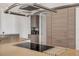 Modern kitchen island with cooktop and stainless hood and appliances at 133 Via Capri, New Smyrna Beach, FL 32169