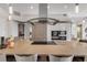 Bright kitchen island features cooktop and stainless hood, and stainless appliances at 133 Via Capri, New Smyrna Beach, FL 32169