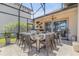 Outdoor kitchen with a grill, countertop, and dining table under a screened enclosure, perfect for entertaining at 133 Via Capri, New Smyrna Beach, FL 32169