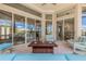 Outdoor living area featuring comfortable seating, a fire pit, and views of the pool and canal through large windows at 133 Via Capri, New Smyrna Beach, FL 32169