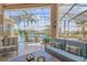 Outdoor living area with comfortable seating, a view of the pool and canal, and a screened enclosure at 133 Via Capri, New Smyrna Beach, FL 32169
