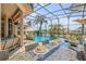 Screened-in patio with an outdoor kitchen, granite countertops, and seating area next to the pool at 133 Via Capri, New Smyrna Beach, FL 32169