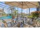 Outdoor dining setup on a screened-in patio with a view of the pool, dock, and waterfront at 133 Via Capri, New Smyrna Beach, FL 32169