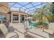 Expansive screened patio and pool area with multiple seating arrangements, perfect for entertaining at 133 Via Capri, New Smyrna Beach, FL 32169