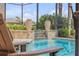 Relaxing view of the screened-in pool with water features, potted plants, and comfortable poolside seating at 133 Via Capri, New Smyrna Beach, FL 32169