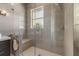Modern shower features glass doors, sleek fixtures, a built-in bench, and neutral tile, creating a spa-like retreat at 133 Via Capri, New Smyrna Beach, FL 32169