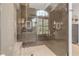 This neutral-tiled shower features rainfall and handheld shower heads and is enclosed with frameless glass at 133 Via Capri, New Smyrna Beach, FL 32169