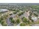 Community aerial shot showcasing lush greenery, buildings, parking, tennis courts, and a pond at 160 Reserve Cir # 204, Oviedo, FL 32765