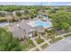 Aerial view of a community pool and clubhouse, landscaped grounds, and a bridge over a body of water at 160 Reserve Cir # 204, Oviedo, FL 32765