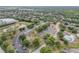 Community aerial showcasing lush greenery, buildings, parking, tennis courts, and the surrounding landscape at 160 Reserve Cir # 204, Oviedo, FL 32765