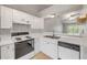 Bright kitchen with white cabinets, countertops, and appliances, featuring a double sink at 160 Reserve Cir # 204, Oviedo, FL 32765