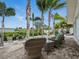 A covered brick patio has outdoor seating that overlooks lush tropical landscaping and waterfront views at 1601 S Riverside Dr, Edgewater, FL 32132