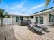 The brick paved patio has lounge chairs and a hot tub, surrounded by mature landscaping at 1601 S Riverside Dr, Edgewater, FL 32132