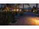 Resort-style backyard with a brick walkway, lush landscaping, and waterfront views at 1601 S Riverside Dr, Edgewater, FL 32132