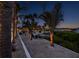 Waterfront backyard featuring palm trees, ambient lighting, gravel, and tranquil water views at 1601 S Riverside Dr, Edgewater, FL 32132