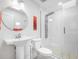 Bright white bathroom with a glass enclosed shower featuring multiple shower heads and a round mirror at 1601 S Riverside Dr, Edgewater, FL 32132