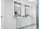 Modern bathroom featuring double sinks, white cabinets and elegant stone accent wall at 1601 S Riverside Dr, Edgewater, FL 32132