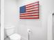 Bathroom with toilet and decorative American flag art, providing a patriotic touch at 1601 S Riverside Dr, Edgewater, FL 32132