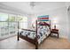 Cozy bedroom with a four-poster bed, ceiling fan, and sunlit windows at 1601 S Riverside Dr, Edgewater, FL 32132