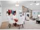 Open dining and living space featuring glass table and chairs next to a fireplace and artwork at 1601 S Riverside Dr, Edgewater, FL 32132