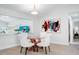 Bright dining room featuring decorative glass table and chairs with artwork, adjacent to other living areas at 1601 S Riverside Dr, Edgewater, FL 32132
