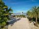Expansive circular driveway leading to a single-story home with lush tropical landscaping and a metal roof at 1601 S Riverside Dr, Edgewater, FL 32132