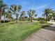 Beautifully landscaped front yard with mature palm trees, lush green grass, and a well-maintained lawn at 1601 S Riverside Dr, Edgewater, FL 32132