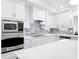 Bright kitchen with new stainless steel appliances, white cabinetry, and a modern backsplash at 1601 S Riverside Dr, Edgewater, FL 32132