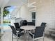 Inviting covered patio with outdoor dining area, ceiling fan, and views of the pool and tropical landscape at 1601 S Riverside Dr, Edgewater, FL 32132