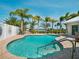 The private backyard pool features a brick surround, lush tropical palms and serene water views at 1601 S Riverside Dr, Edgewater, FL 32132