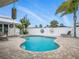 Beautiful kidney-shaped pool with brick surround, white fencing, and mature palm tree at 1601 S Riverside Dr, Edgewater, FL 32132