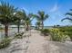 A paved walkway leads to the waterfront, flanked by lush landscaping and palm trees at 1601 S Riverside Dr, Edgewater, FL 32132