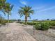 A stone paved walkway leads to the waterfront, flanked by lush landscaping and palm trees at 1601 S Riverside Dr, Edgewater, FL 32132