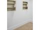 A plain white wall with neutral toned trim featuring two inset storage cabinets with open shelves at 1601 S Riverside Dr, Edgewater, FL 32132