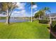 View of the lake and generous backyard with mature landscaping, and enclosed pool at 1688 Town Park Dr, Port Orange, FL 32129