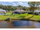 Beautiful backyard view of screened pool, pond, and lush landscaping on a sunny day at 1688 Town Park Dr, Port Orange, FL 32129
