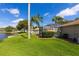 View of the generous backyard with mature landscaping, lake, and enclosed pool at 1688 Town Park Dr, Port Orange, FL 32129