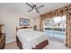 Well-lit bedroom with access to a private pool, enhanced by stylish decor and a ceiling fan at 1688 Town Park Dr, Port Orange, FL 32129