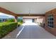 Long concrete carport featuring a brick exterior and access to an attached garage at 1688 Town Park Dr, Port Orange, FL 32129