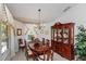 Formal dining room features elegant chandelier, custom drapery, and polished wood table and china cabinet at 1688 Town Park Dr, Port Orange, FL 32129