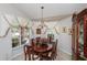 Formal dining room features elegant chandelier, custom drapery, and polished wood table at 1688 Town Park Dr, Port Orange, FL 32129