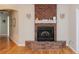 Traditional brick fireplace with white mantel, complementing the hardwood flooring and sconce lighting at 1688 Town Park Dr, Port Orange, FL 32129